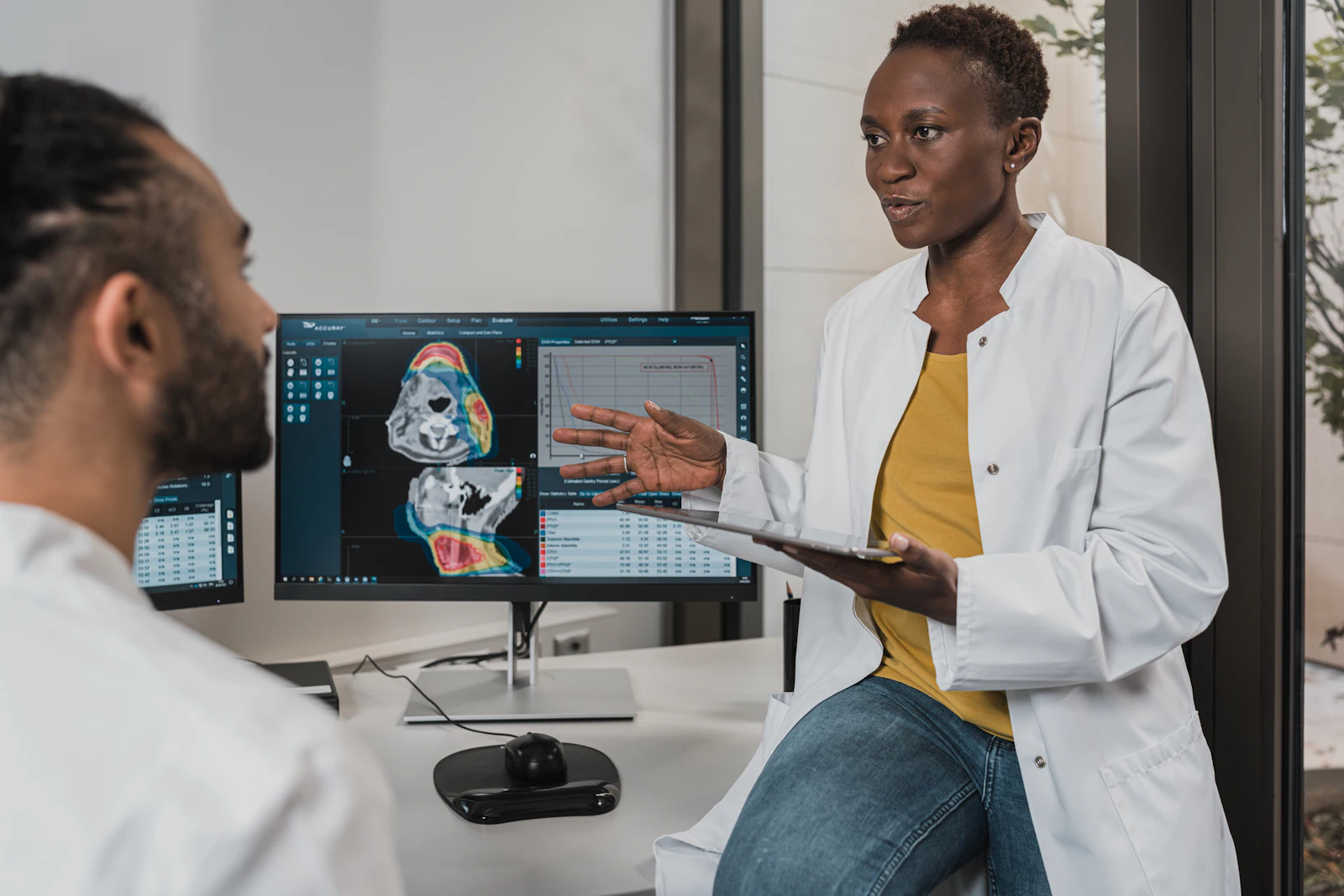 A specialist reviewing diagnostic imaging on screen with a colleague
