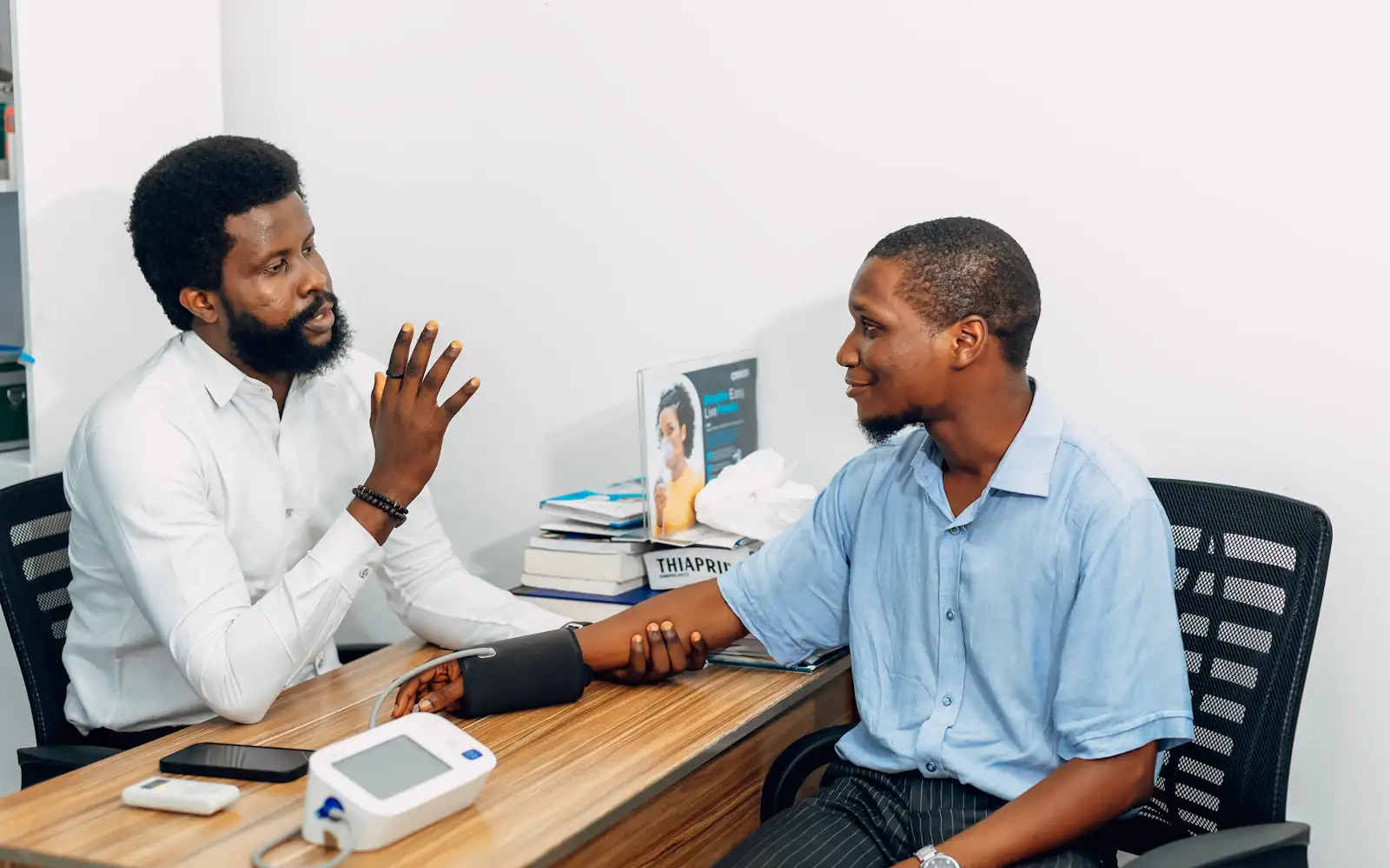A doctor in consultation with a patient, checking his blood pressure