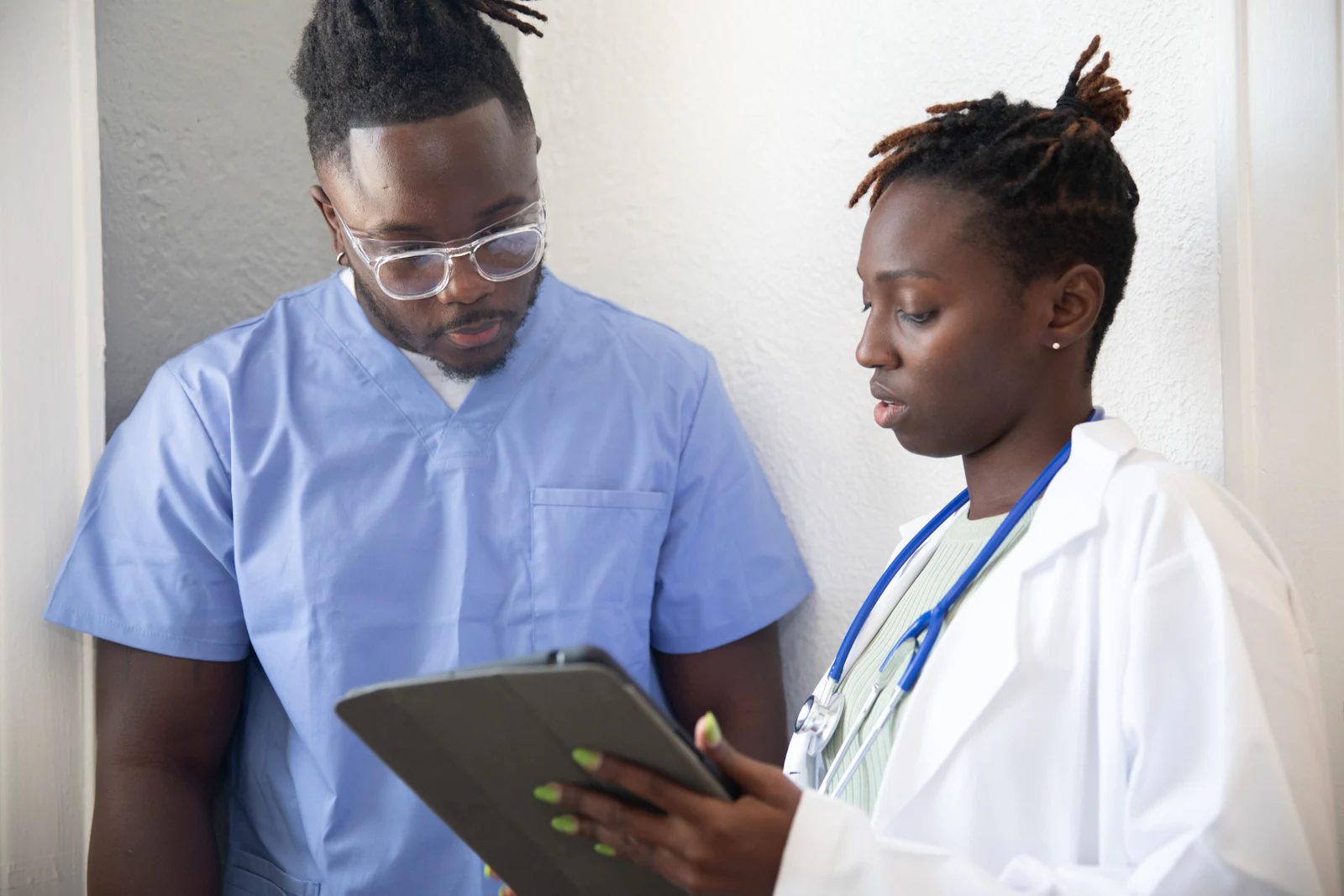Two clinicians reviewing patient information on a tablet