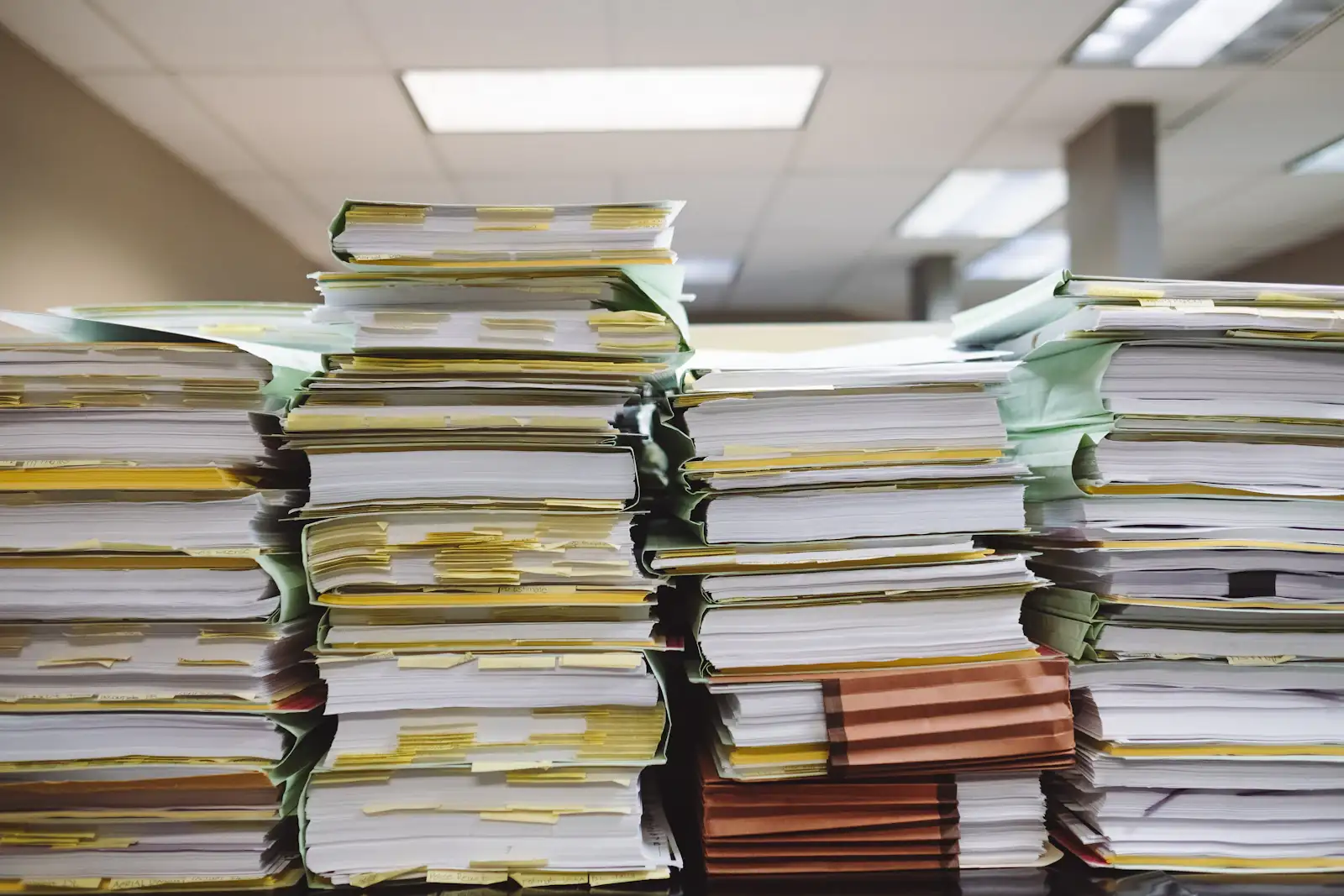 Stacks of paper files and folders on a desk